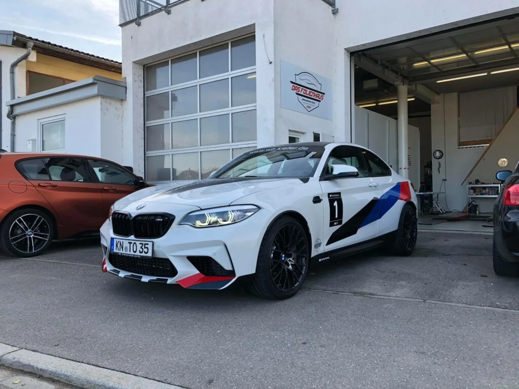 Man sieht die Seite eines BMWs mit frischer Teilfolierung.