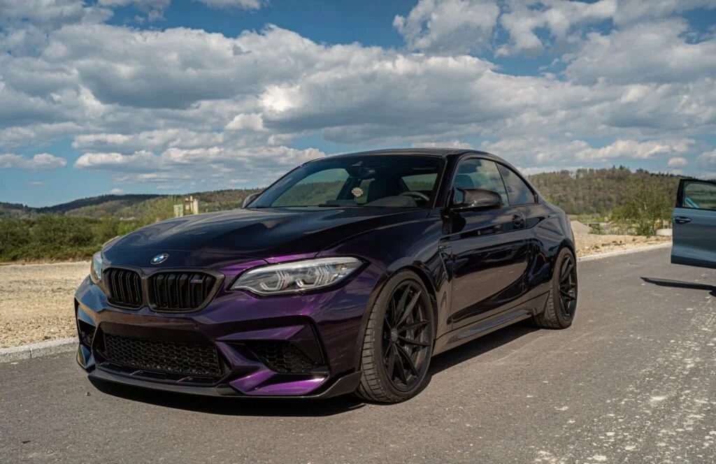 Lila BMW mit aufgetragener Steinschlagschutzfolierung steht Draußen.